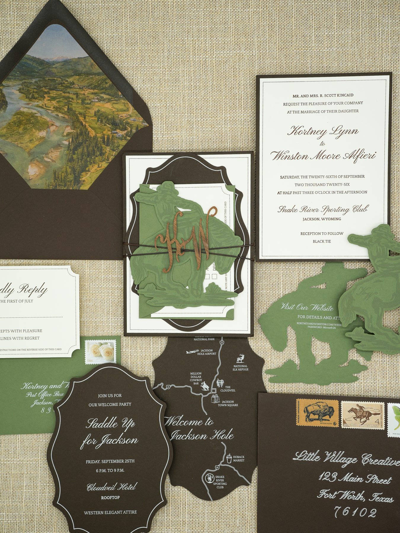 A full custom wedding invitation suite by Little Village Creative Co., featuring a hand-illustrated mountain map, watercolor landscape envelope liner, die-cut sage cowboy silhouettes, and vintage stamps.