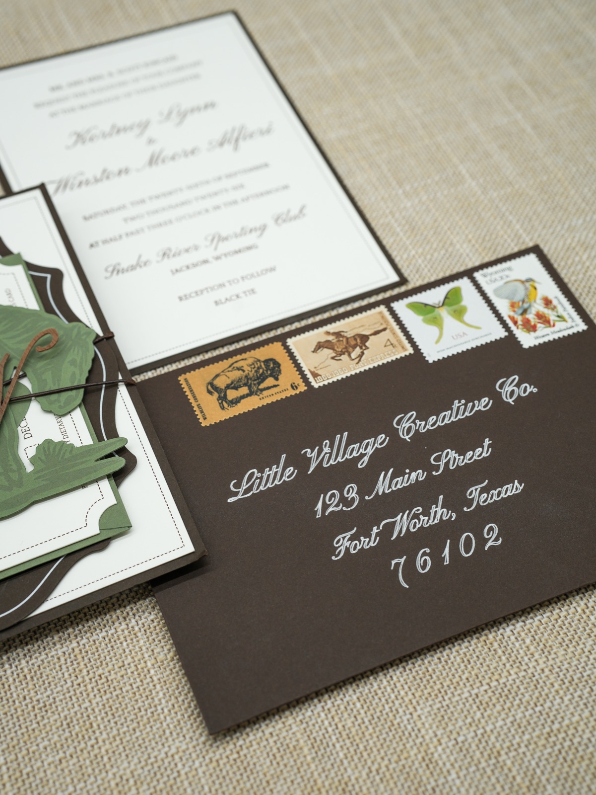 A brown envelope addressed in white calligraphy with western vintage stamps.