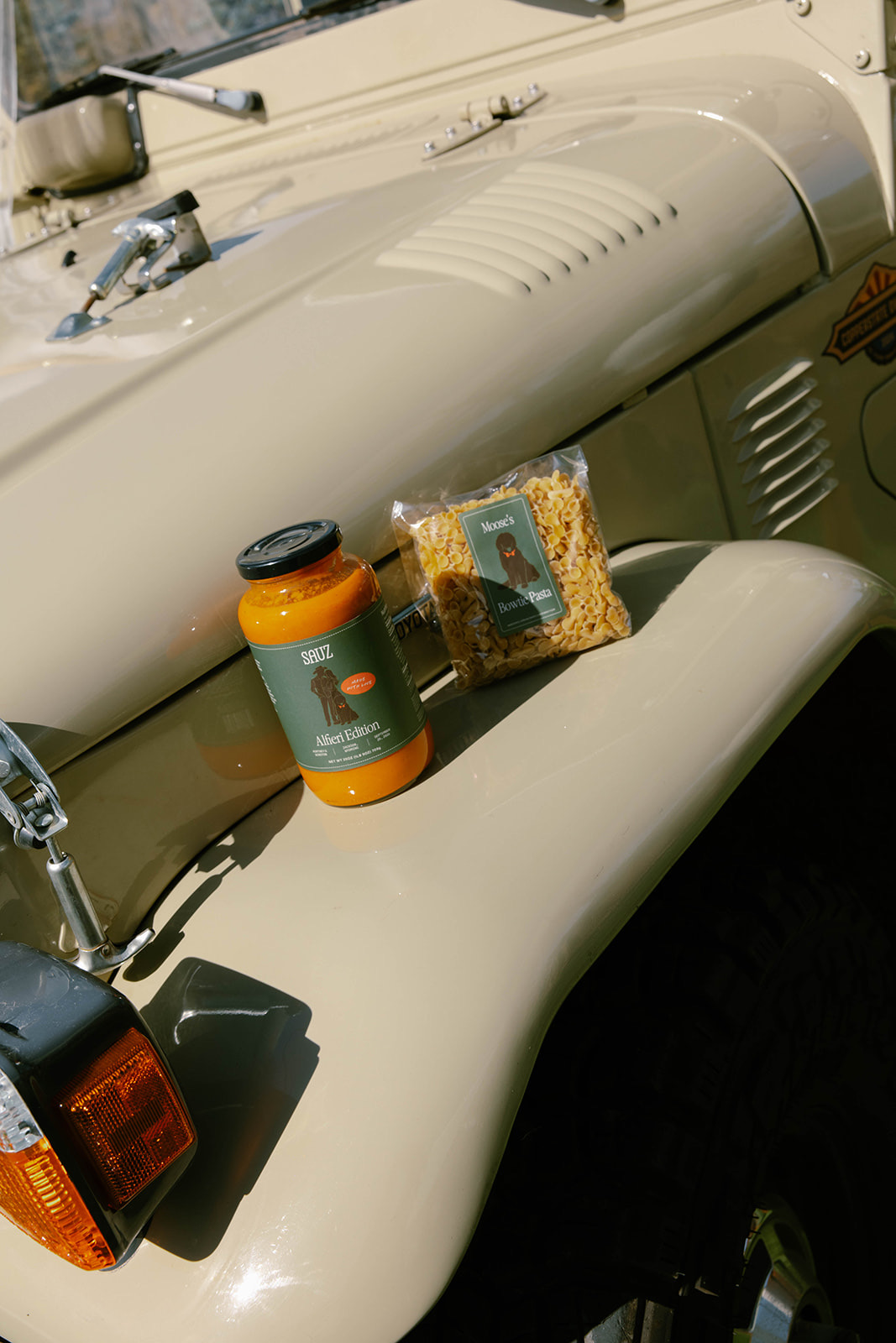 A custom sauce bottle resting on the cream vintage getaway car.