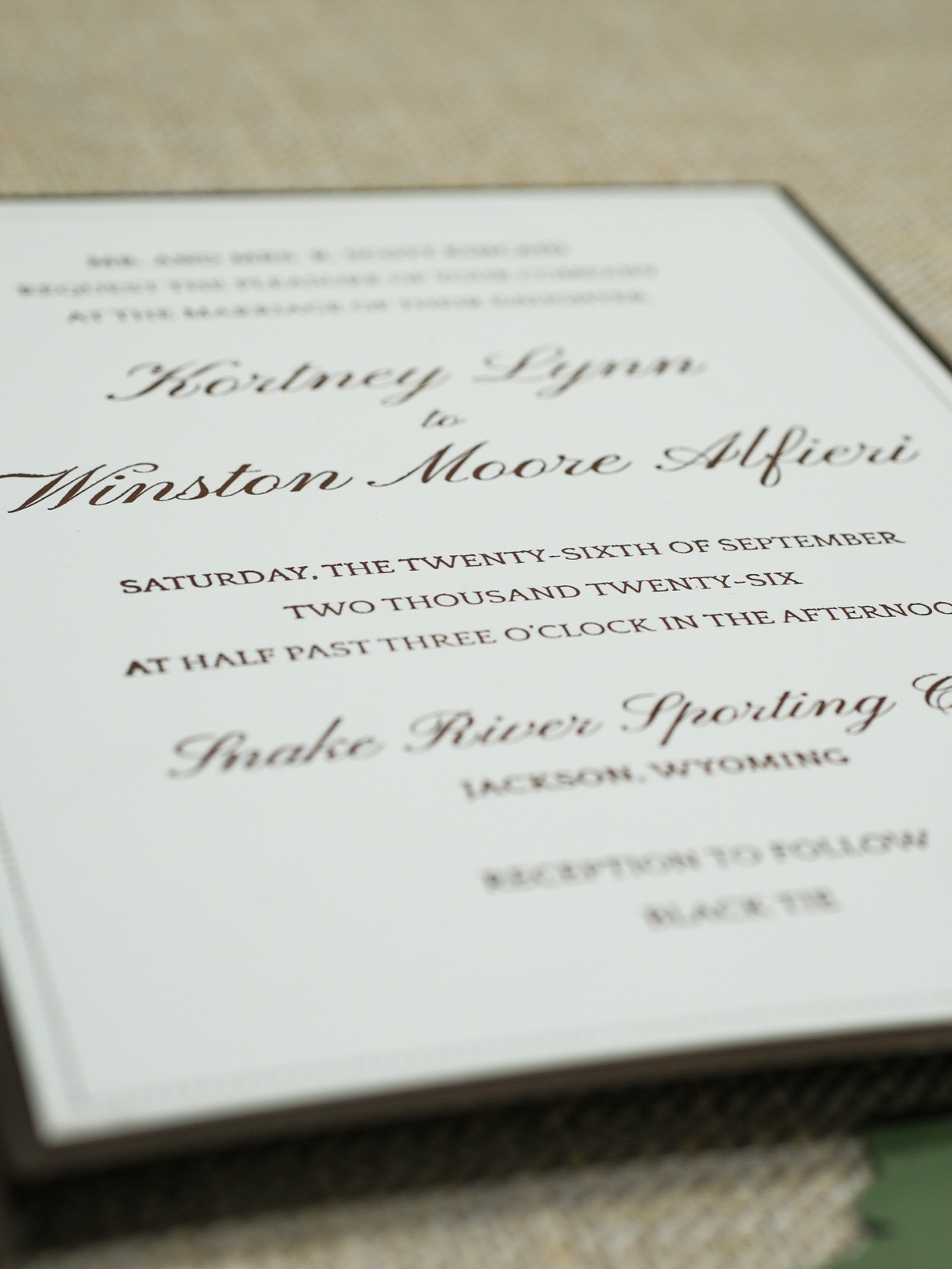A close view of the letterpress invitation lettered in chocolate brown.