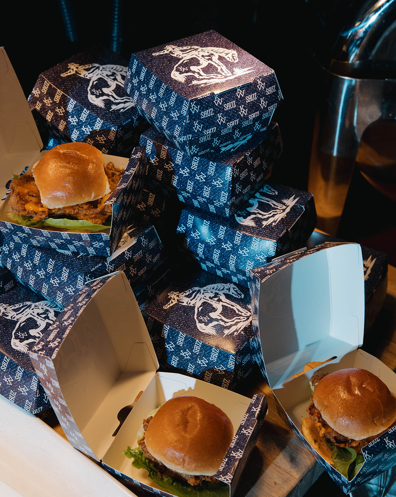 Late-night slider boxes in the suite's blue western toile print, stacked for guests.