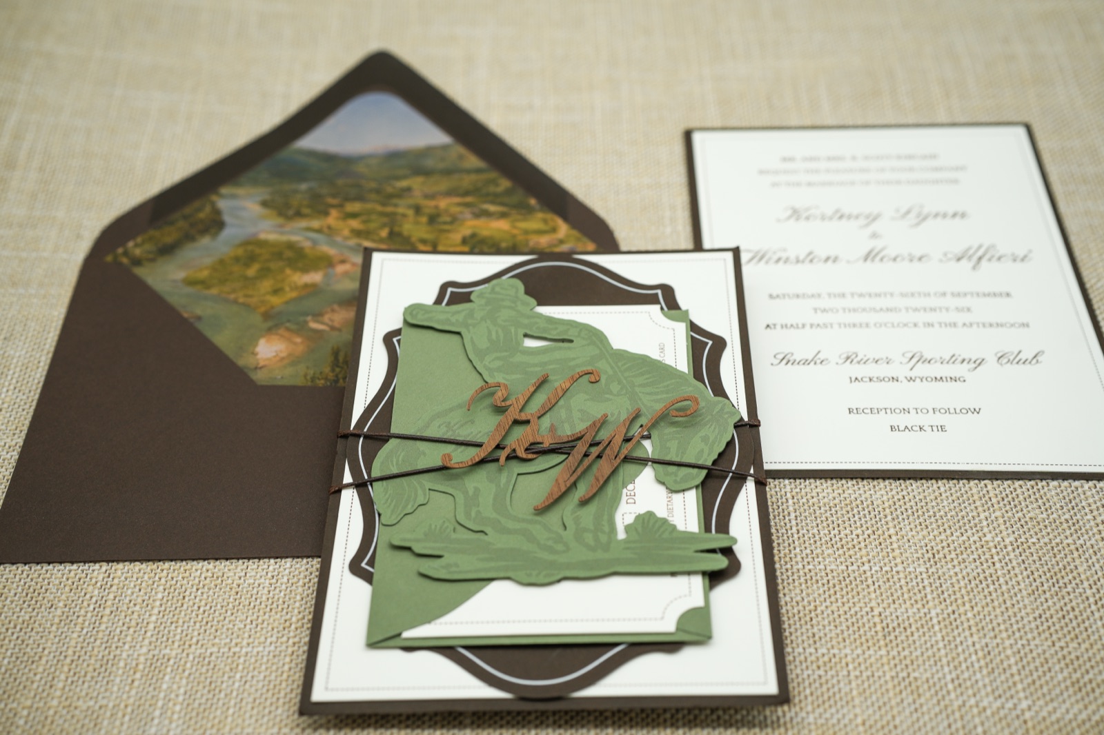 The invitation resting on the watercolor valley liner in its brown envelope.
