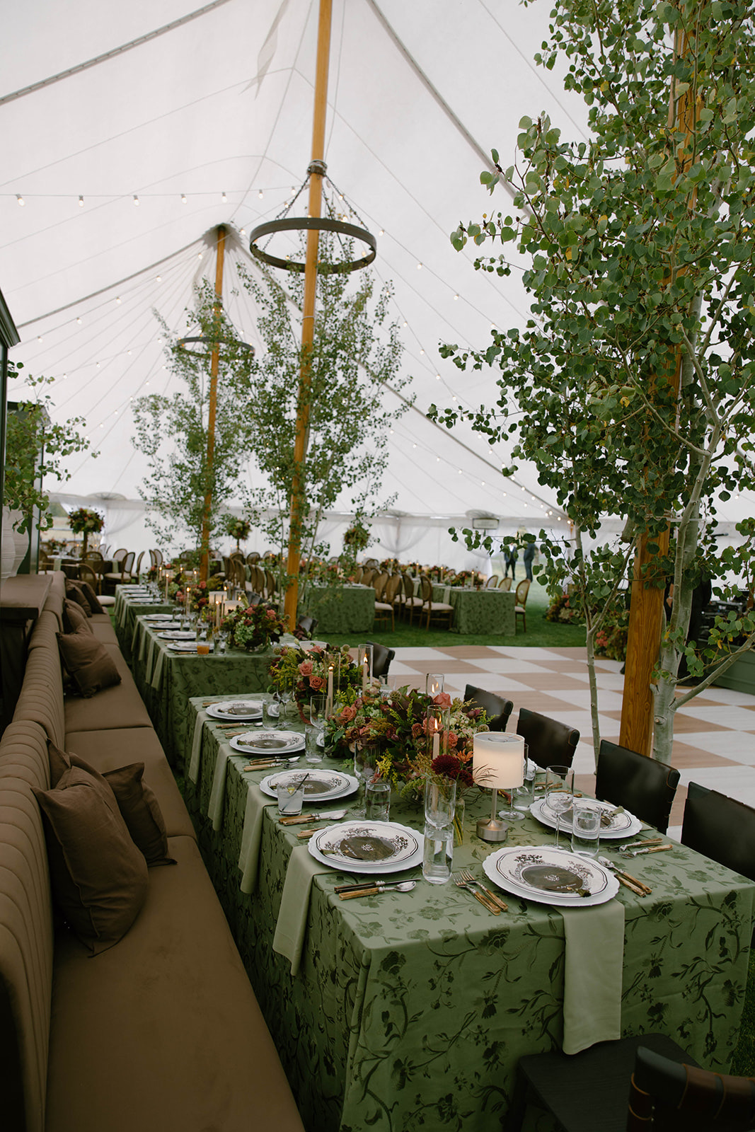 The reception tent with long tables and young trees brought inside.