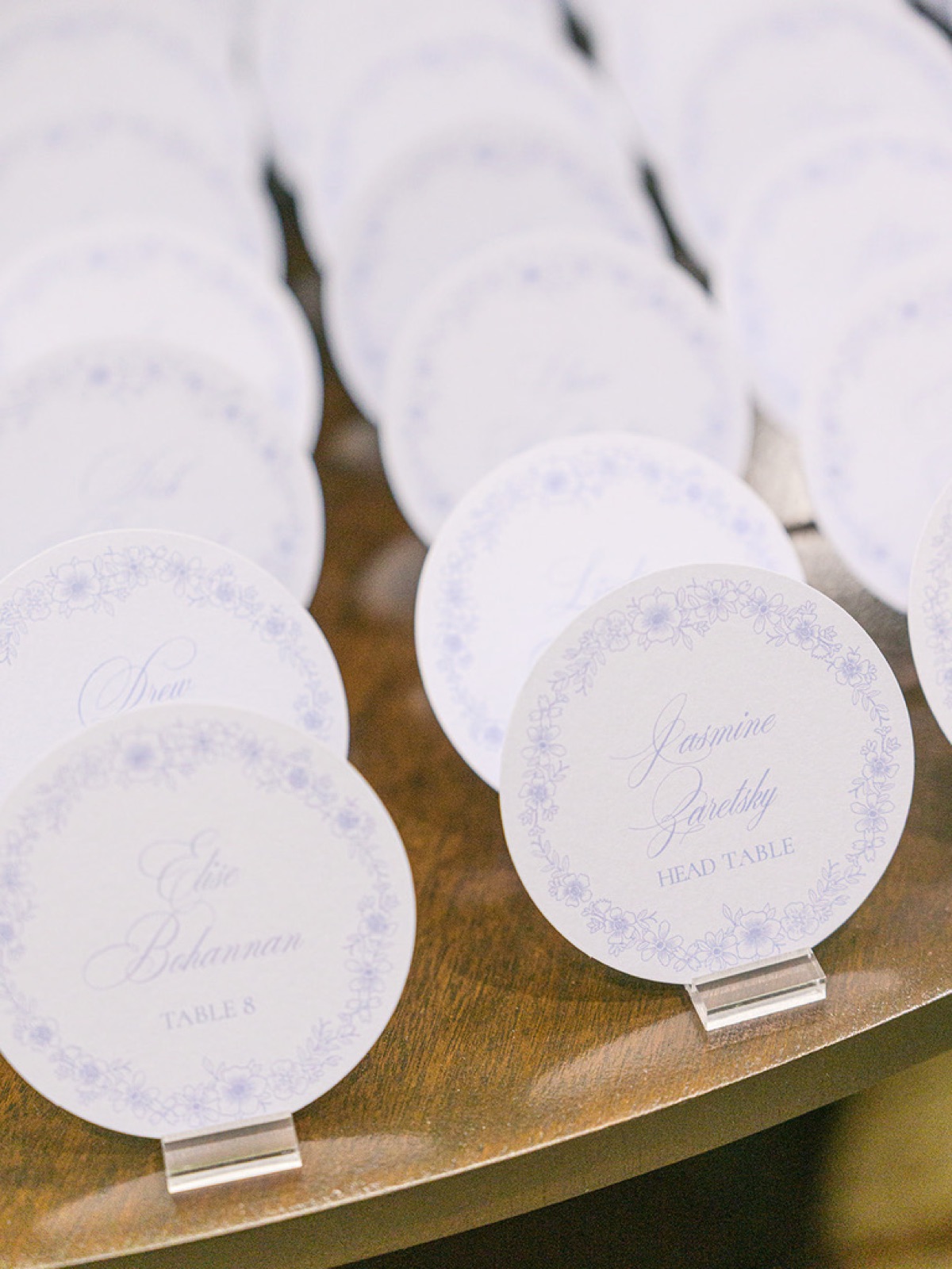 Rows of round escort cards with delicate floral borders.