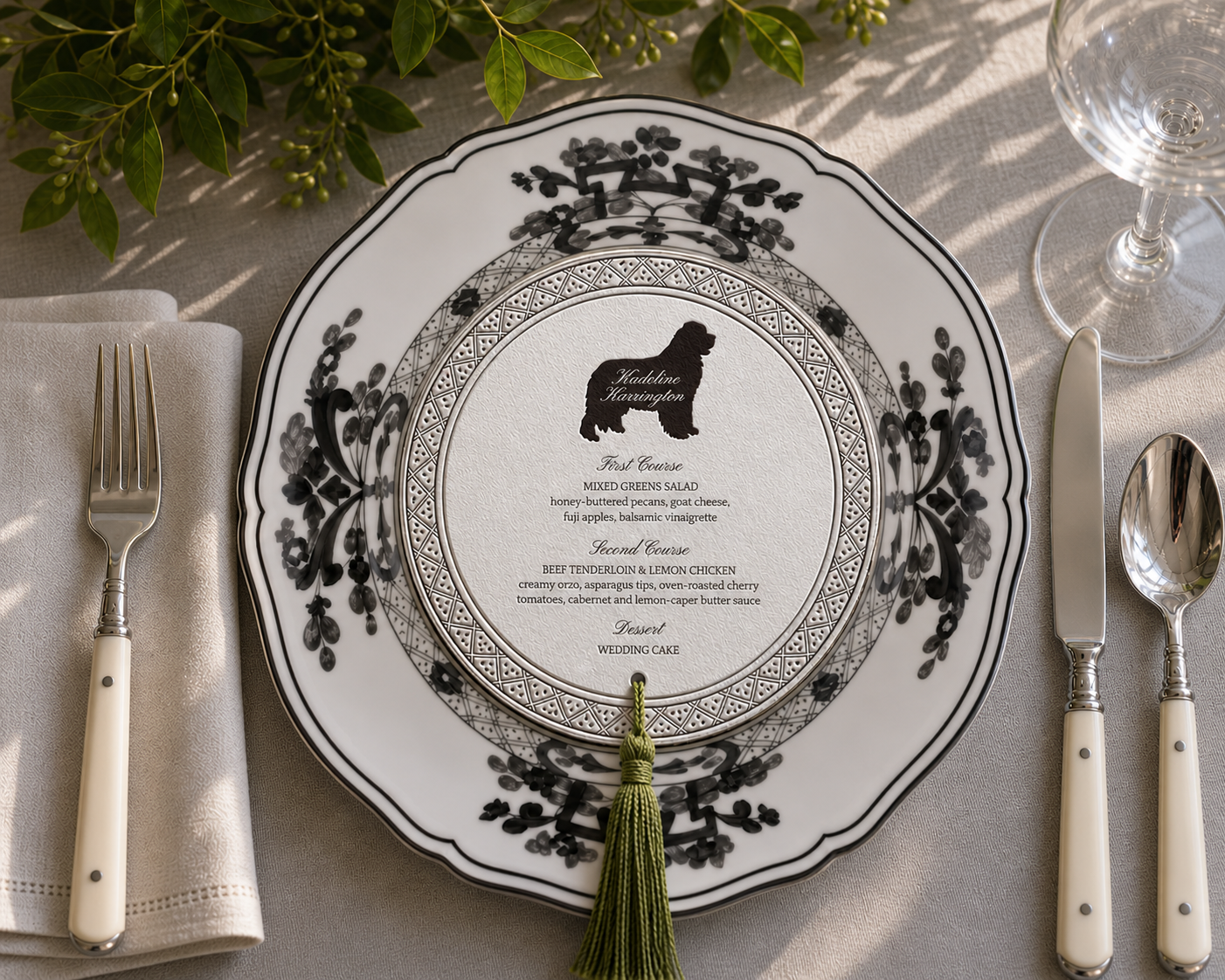 Custom die-cut wedding menu printed on a charger plate, with greenery and a tassel.