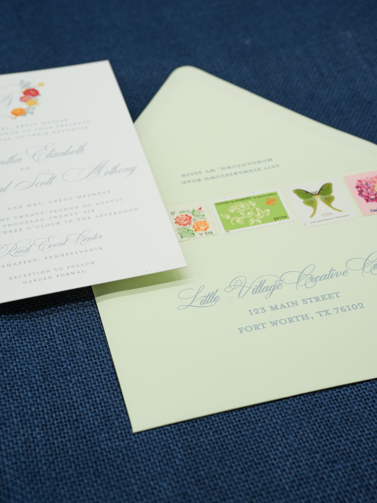 A soft green envelope addressed in calligraphy with garden vintage stamps.