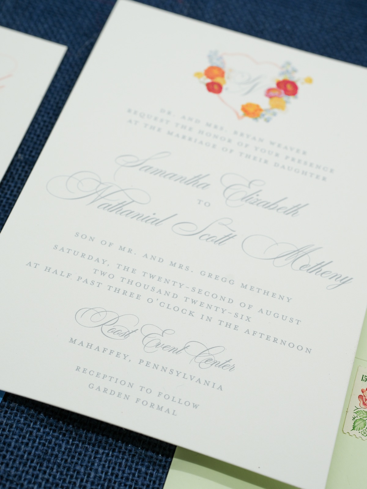 The invitation: a watercolor floral crest over calligraphy on double-thick cream stock.