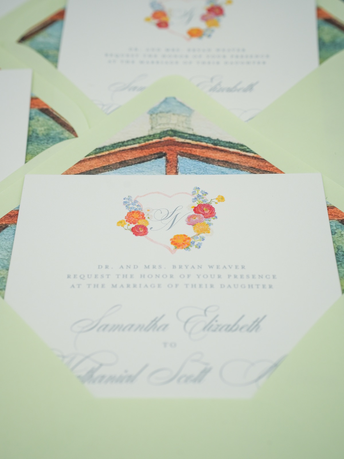 Invitations and chapel-lined envelopes layered across the table.