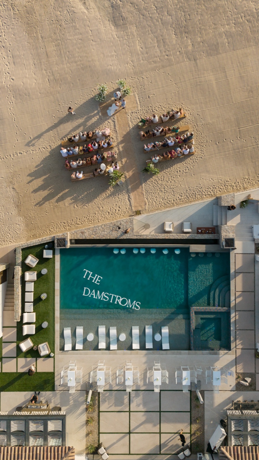 An aerial view of the pool deck lettered for the couple, beside rows of beach seating.