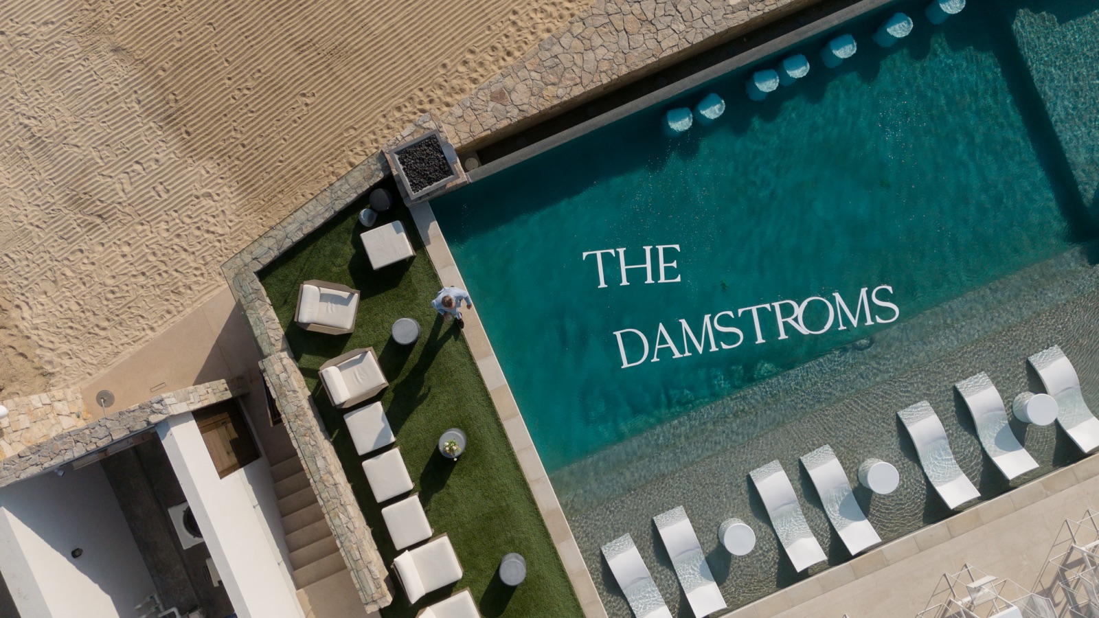 An aerial view of the lettered pool deck and rows of beach seating.