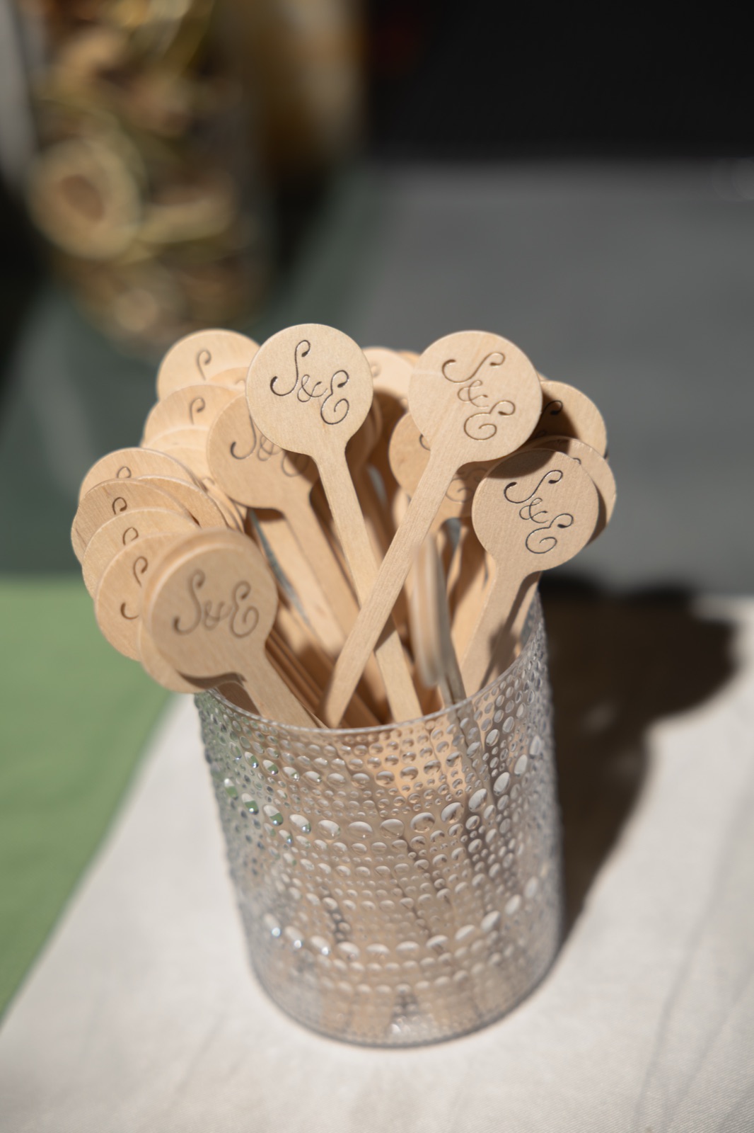 Monogrammed drink stirrers gathered in a hammered silver cup.