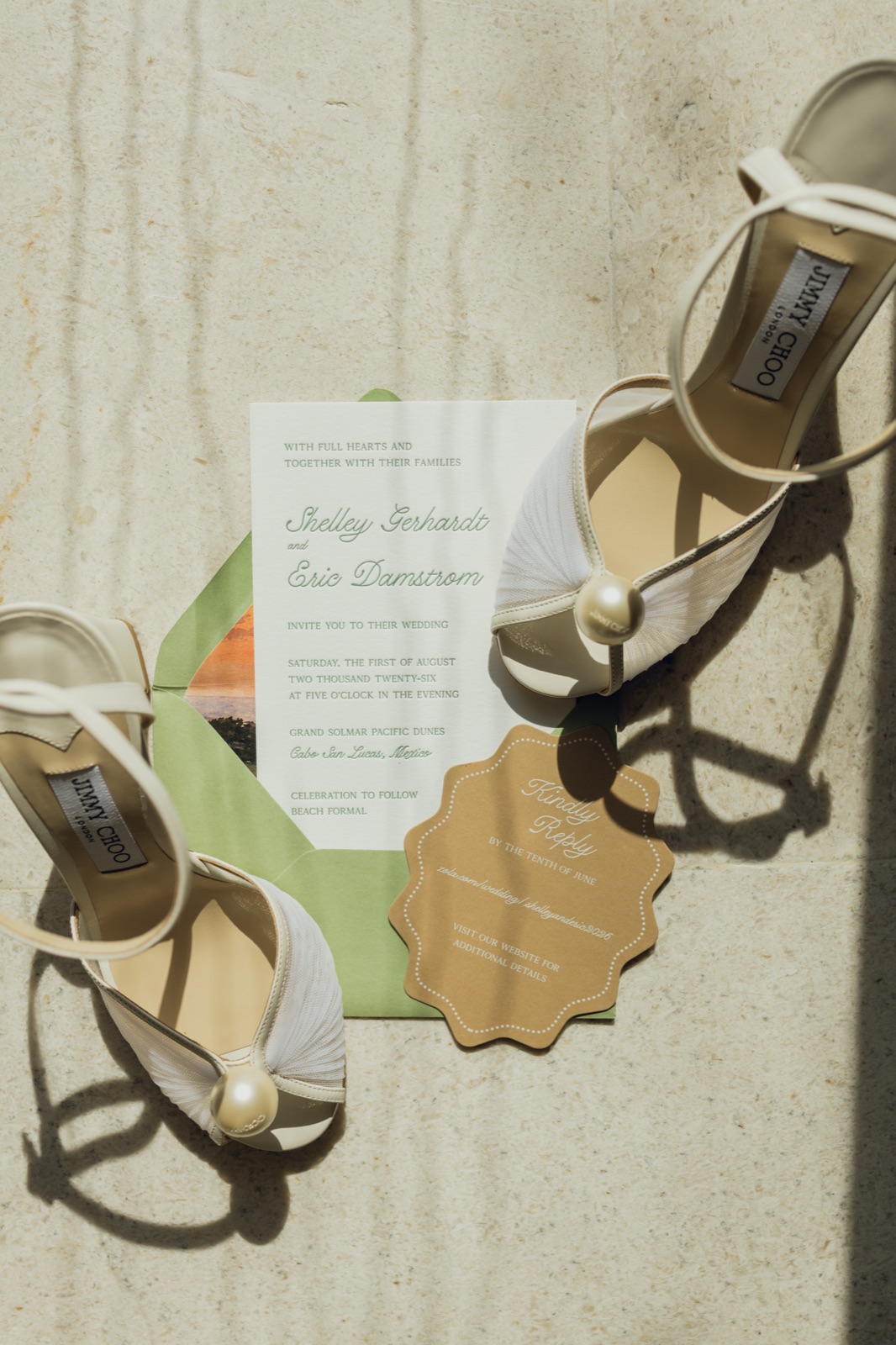 The invitation and kraft tag styled with pearl heels in the sun.